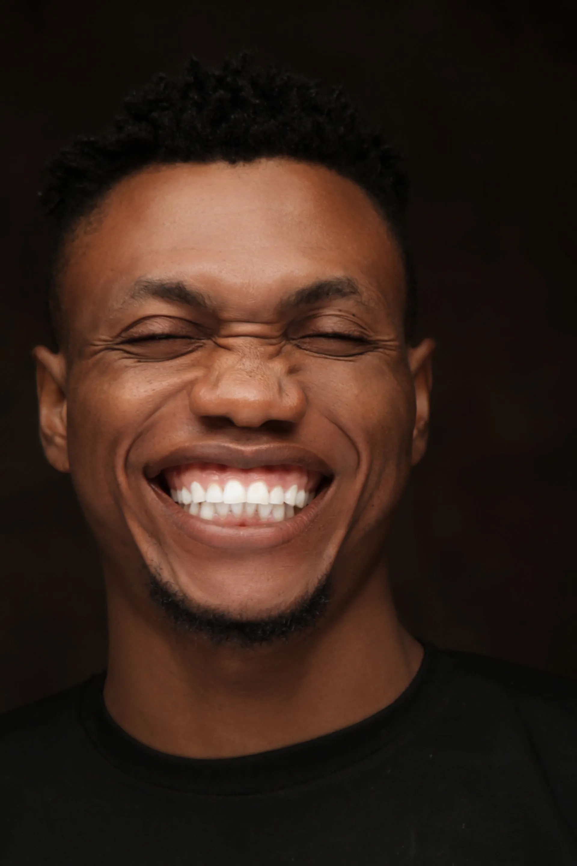 Retrato de una persona sonriendo con una dentadura blanca y natural