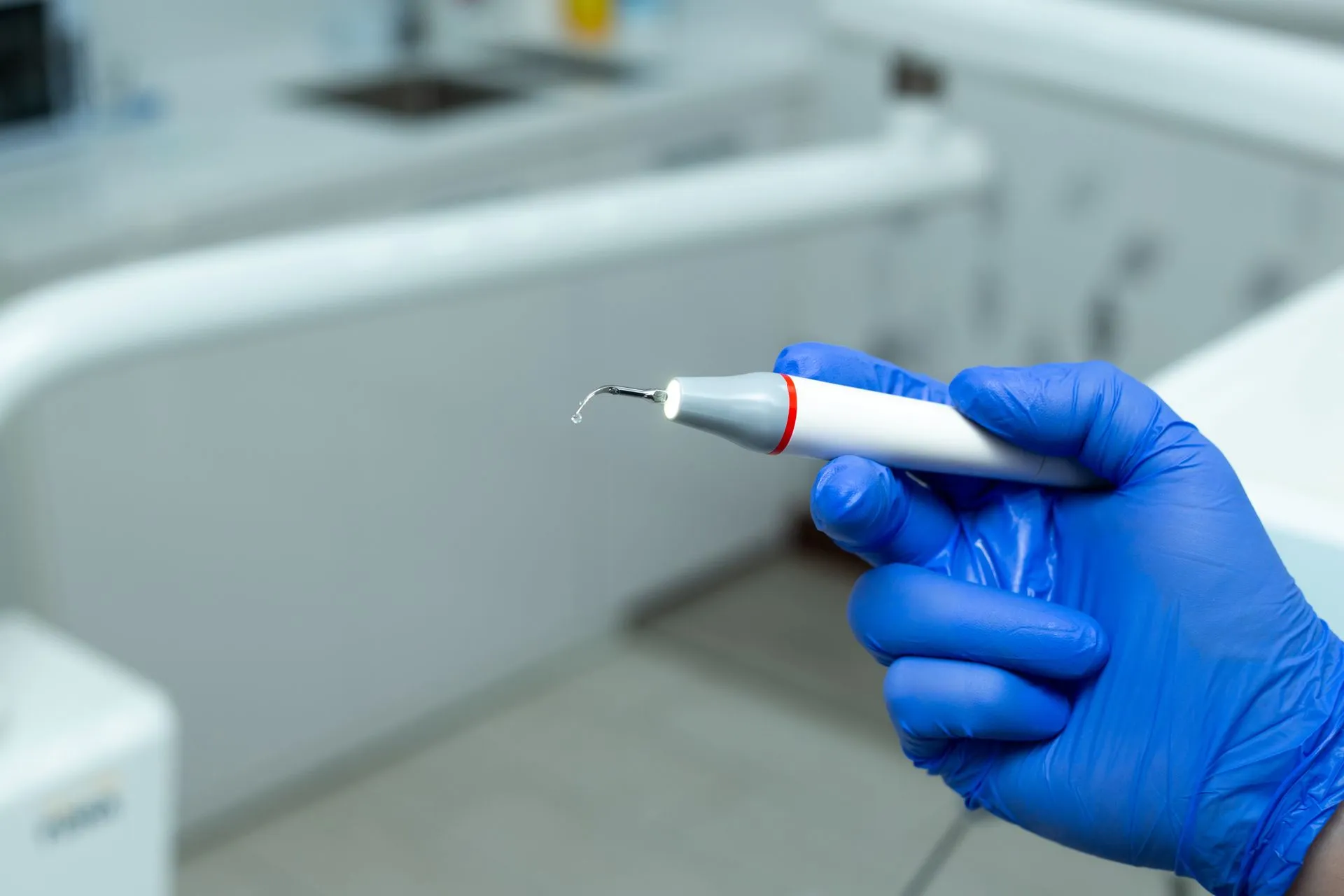 Profesional dental realizando una limpieza de encías con instrumental